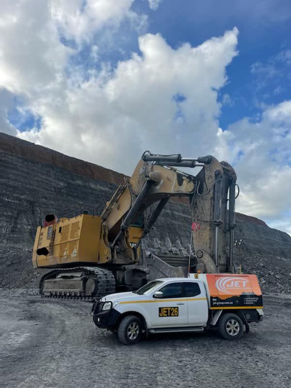 Pickup truck infront of Excavator - Jet Mining Services